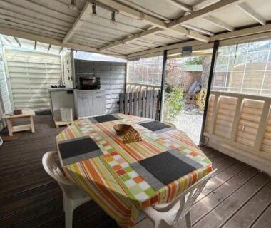 Terrasse couverte avec table, chaises et kitchenette dans le Coquet mobilehome 8 places