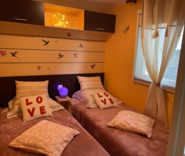 Chambre avec deux lits jumeaux et coussins love dans le Coquet mobilehome 8 places