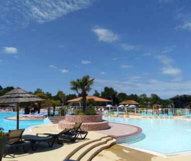 Piscine extérieure avec parasols et transats au camping Cordon LMP