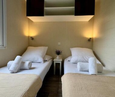 Chambre avec deux lits et fenêtre dans le Cosy mobil-home wifi clim