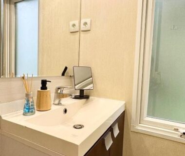 Salle de bain avec lavabo miroir et fenêtre dans le Cosy mobil-home wifi clim