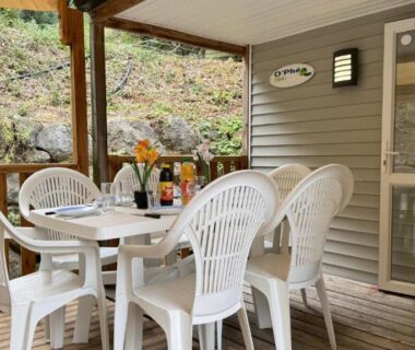 Terrasse couverte avec table et chaises blanches du Cosy mobil-home wifi clim