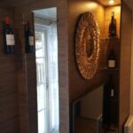 Intérieur avec miroir mural, télévision et étagères à vin dans le mobilhome Côte d'Émeraude