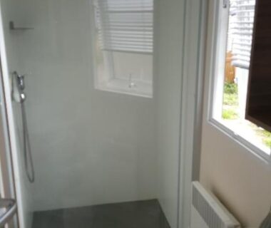 Salle d'eau avec douche vitrée et lavabo dans le mobilhome Côte d’Émeraude Mobilhome