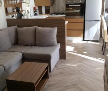 Salon avec canapé et kitchenette dans le mobilhome Côte d'Émeraude Mobilhome
