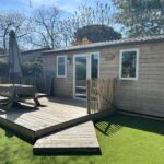 Terrasse en bois avec table et parasol du Cottage Essentiel 30m2