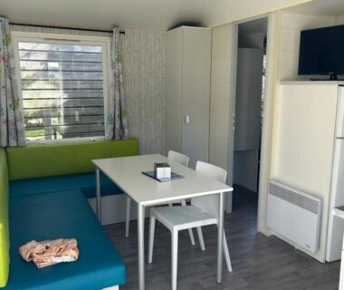 Séjour avec banquette table et télévision dans le Cottage Essentiel 30m2