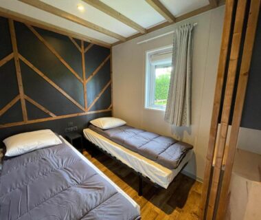 Chambre avec deux lits et fenêtre dans le Cottage Grand Fay à 10 min des plages