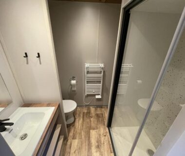 Salle de bain avec douche vitrée lavabo et WC du Cottage Grand Fay