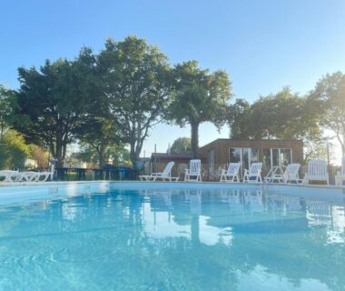 Piscine extérieure avec transats et arbres au Cottage Grand Fay