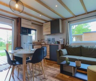 Salon et kitchenette avec baie vitrée donnant sur jardin du Cottage Grand Fay