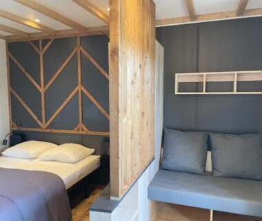 Intérieur avec lit et banquette dans le Cottage Grand Fay