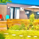 Terrasse en bois avec chaises et pelouse en Normandie au Cottage Premium