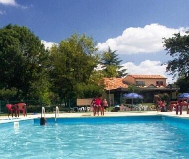 Piscine extérieure avec parasols et chaises au camping en Dordogne Cottage avec terrasse – 8 pers. – API-1-52-2214