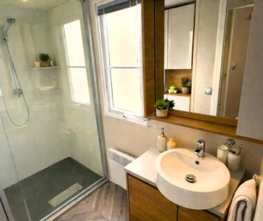 Salle de bains avec douche vitrée et lavabo dans le Cozy-House tout confort camping 4 étoiles
