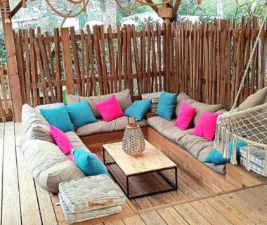Terrasse couverte en bois avec banquette et hamac au Cozy-House tout confort camping 4 étoiles