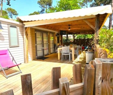 Terrasse en bois avec table à manger et transat rose du Cozy-House tout confort camping 4 étoiles