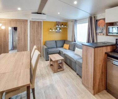 Salon avec coin repas et kitchenette dans le Cozy Stacaravan In Saint-Julien-En-Born