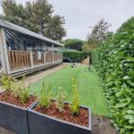 Terrasse couverte et pelouse devant le mobil-home au camping Détente et Lac