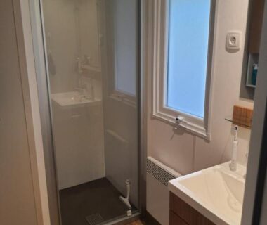Salle de bain avec cabine de douche et lavabo au camping Détente et Lac
