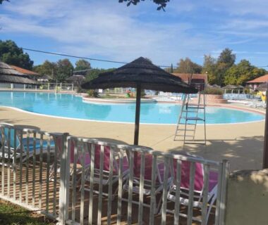Bord de piscine avec parasol et transats au camping Détente et Lac
