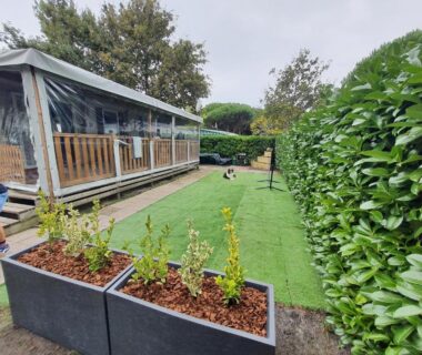 Terrasse couverte et pelouse devant le mobil-home au camping Détente et Lac