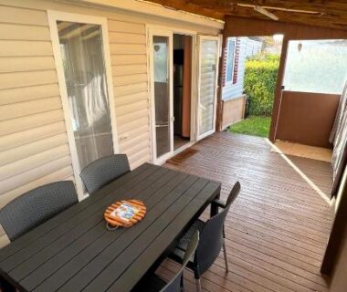 Terrasse couverte avec table et chaises du camping Détente et nature au bord du Rhône