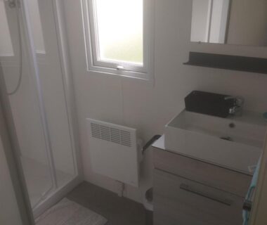 Salle de bains avec douche et lavabo dans le Domaine
