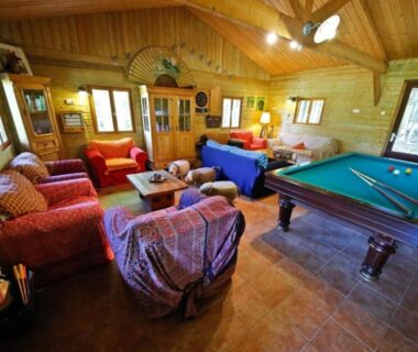 Salle de détente avec billard et canapés dans le gîte La Cigogne au Domaine La Faix