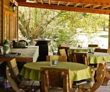 Terrasse couverte avec tables et chaises au Gite La Cigogne