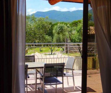 Terrasse avec table et chaises donnant sur les montagnes au Domaine La Pietra