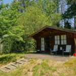 Chalet en bois avec terrasse dans la végétation au Domaine La faix Gite le Verger