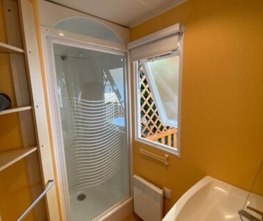 Salle de bain avec cabine de douche et lavabo dans le mobile home du Domaine Les Abberts