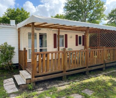 Terrasse en bois devant mobil-home avec pergola au Domaine Les Abberts