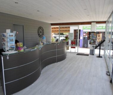 Hall d'accueil avec comptoir et brochures au Domaine Les Abberts