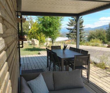 Terrasse couverte avec salon et table à manger et vue sur les montagnes au Domaine Napoléon