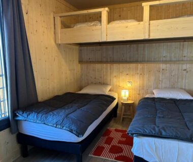 Chambre en bois avec lits superposés et deux lits simples au Domaine Napoléon