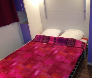 Chambre avec lit double et couverture rouge au Domaine Plein Sud