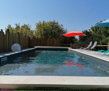 Piscine extérieure avec parasols et transats du Domaine QUIESCIS