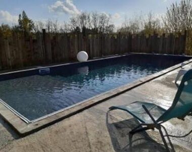 Piscine extérieure avec transat et margelle en pierre au Domaine QUIESCIS