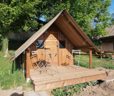 Terrasse en bois devant bungalow avec chaises au Domaine QUIESCIS