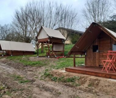 Cabanes en bois sur terrain herbeux avec chaises orange au Domaine QUIESCIS