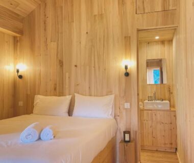 Chambre en bois avec lit et serviettes au Domaine St-Amand