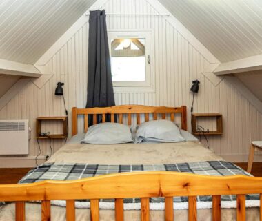Chambre mansardée avec lit double et fenêtre sous pente au Domaine de Guillaume
