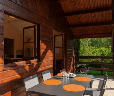 Terrasse en bois avec table et chaises au Domaine de Guillaume
