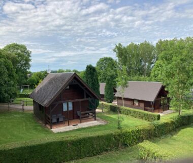 Chalets en bois dans un parc verdoyant au Domaine de Guillaume