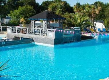 Piscine extérieure avec transats et plantes au Domaine de Kerlann