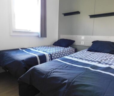 Chambre avec deux lits simples et fenêtre dans le mobil home Domaine de Kerlann