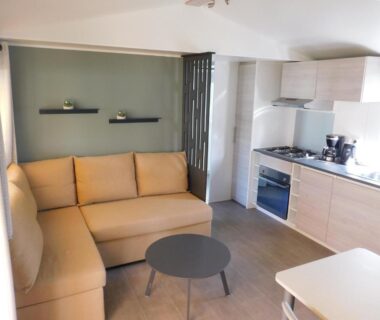 Intérieur avec salon et kitchenette du mobil home 315 au Domaine de Kerlann