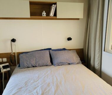 Chambre avec lit double, chevets et étagère au Domaine de Kerlann